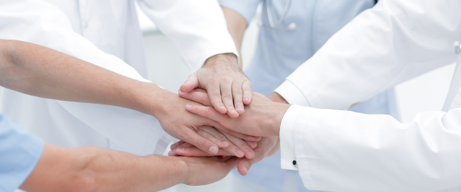doctors holding hands together at hospital